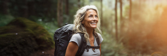 Woman hiking, looking towards the sun.