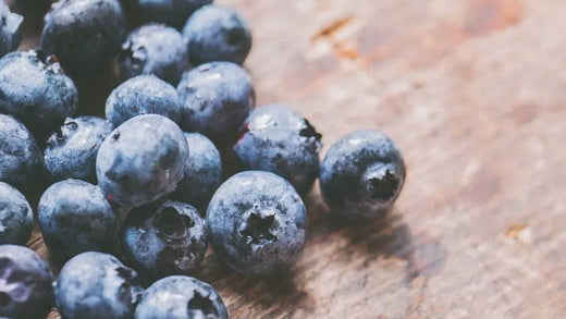 A handful of washed blueberries on a cutting board.