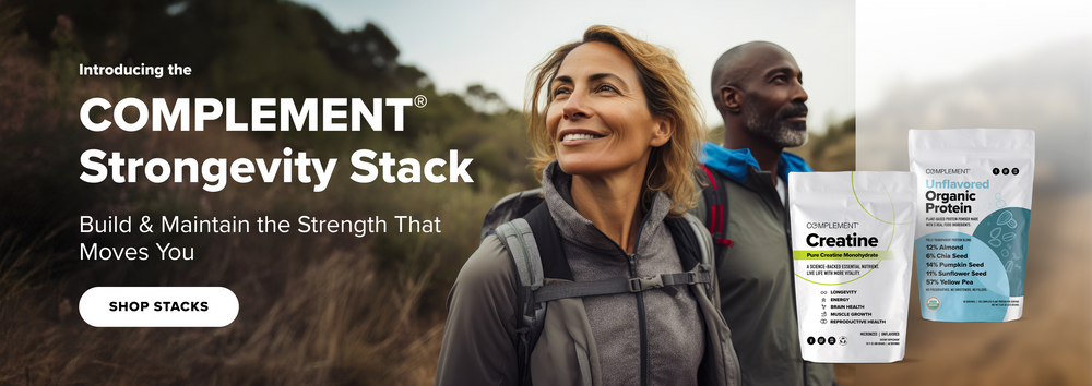 A smiling woman and a man hike outdoors. In the foreground are two protein supplement bags labeled “COMPLEMENT Creatine” and “Unflavored Organic Protein.” Text reads: COMPLEMENT Strongvity Stack. Build & Maintain the Strength That Moves You.
