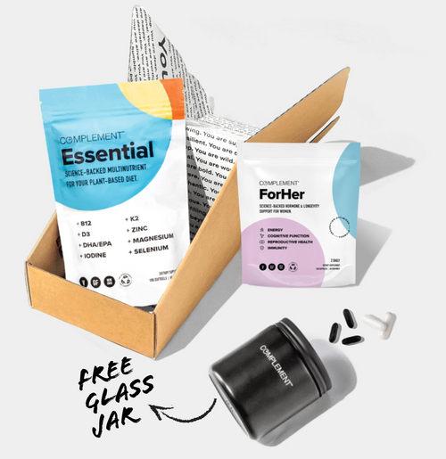 Packaging for Complement Essential and Complement ForHer dietary supplements alongside a black glass jar and capsules, positioned on a white background with a cardboard box. Text indicates a Free Glass Jar.