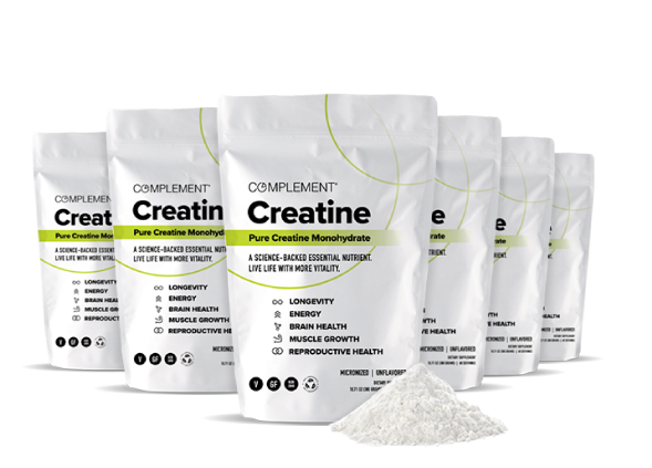 Multiple white bags of Complement Creatine Monohydrate are lined up. The packaging highlights benefits such as longevity, energy, brain health, muscle growth, and reproductive health. A small pile of creatine powder is visible in front.