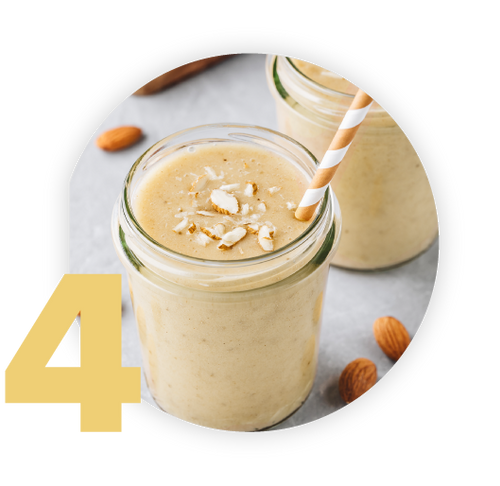 A creamy banana smoothie in a glass jar, topped with almond slices and a striped straw. Another smoothie jar and scattered almonds are in the background. A large yellow number 4 is displayed on the image.