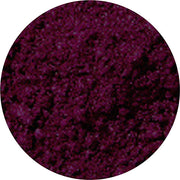 A close-up view of a circular patch of deep purple velvet fabric, showing its soft texture and rich color.