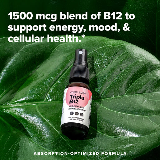 A bottle of Complement Triple B12 spray sits on a large green leaf. Text above reads, 1500 mcg blend of B12 to support energy, mood, & cellular health.* Text below reads, Absorption-optimized formula.