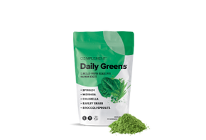 Image of a green and white package labeled Complement Daily Greens. It lists ingredients: spinach, moringa, chlorella, barley grass, and broccoli sprouts. A small pile of green powder is at the base of the package.