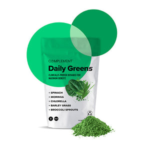 A product package labeled Daily Green 5 featuring green powder ingredients: spinach, moringa, chlorella, barley grass, and broccoli sprouts. The package is white with green accents, and there is a small heap of green powder beside it.