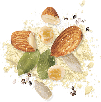 A cluster of almonds, almond flour, and whole almonds with their brown shells and green leaves. Two peeled almonds and scattered seeds surround them on a white background.