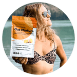 A person in a leopard-print swimsuit and sunglasses stands by a lake, holding a bag of Gut Nurture supplement. The package highlights benefits like optimal digestion and nutrient absorption.