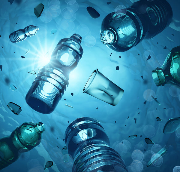 Plastic bottles and debris float underwater with sunlight filtering through, highlighting the pollution and environmental impact of plastic waste in the ocean.