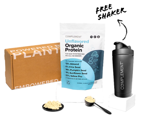 A brown box labeled Powered by Plants is next to a standing pouch of unflavored organic protein powder. A black shaker with the word Complement is on the right. Two scoops of the protein powder are placed in front of the pouch.
