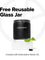 A black reusable glass jar labeled COMPLEMENT® Essential by Complement sits on a white block next to mint leaves and a black capsule, highlighting its plant-based formula. Text: Free reusable glass jar with subscription starter kit.