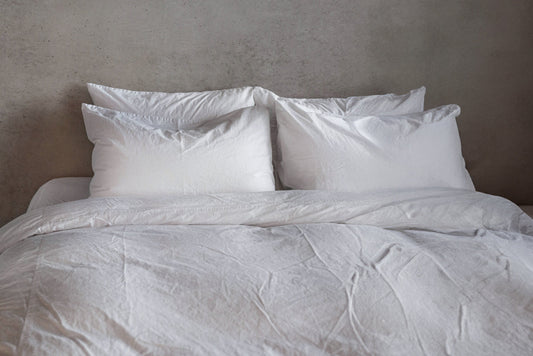 Cozy bed with white sheets and pillows