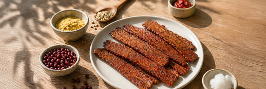 White plate with plant-based vegan bacon and small bowls of ingredients.