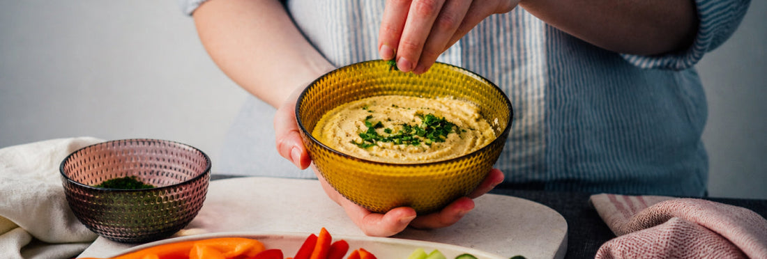 Woman making a bowl of hummus