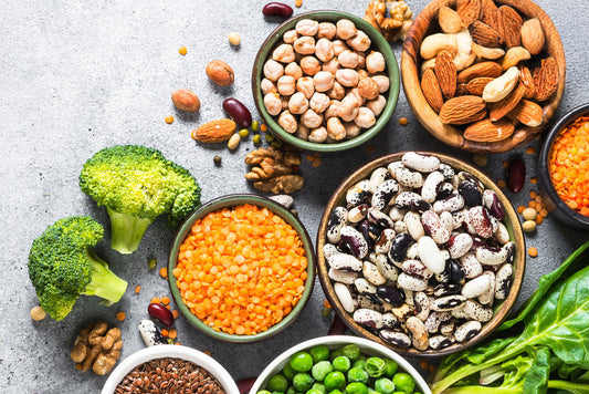 Bowls on a table with beans, lentils, and broccoli