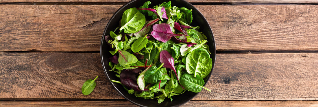 Bowl with a salad on a wooden table. 