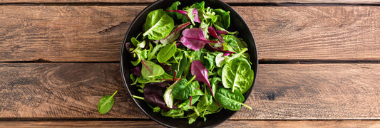 Bowl with a salad on a wooden table. 