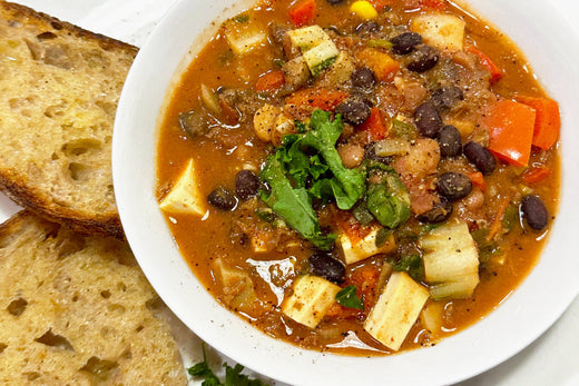 A bowl of tofu chili with two slices of bread