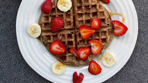A waffle with slices of banana and strawberries