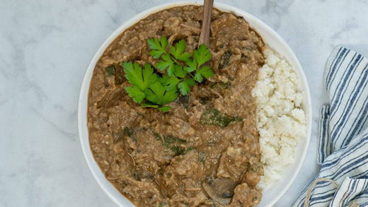 A bowl of curry and rice, garnished with cilantro.