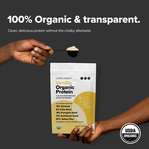 Two hands hold Complement Vanilla Organic Protein powder and a spoonful of the powder against a gray background. The packaging highlights its organic ingredients and USDA Organic certification.