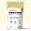 A beige and white pouch labeled COMPLEMENT Bone Vitality stands upright, with some powder spilled in front. The packaging highlights benefits like strong bones and 400 mg calcium per serving.