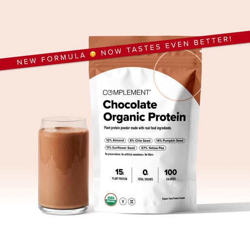 A glass of chocolate protein shake beside a bag labeled Complement Chocolate Organic Protein. Banner above reads, New formula, now tastes even better! Packaging highlights plant protein, 0g sugar, and 100 calories.