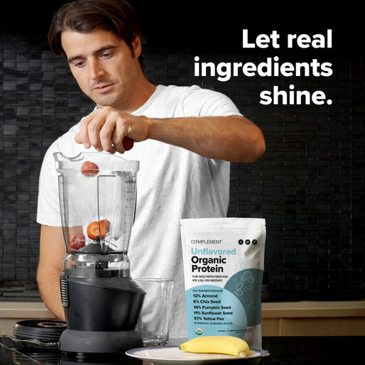 A man in a white shirt places strawberries into a blender. In front of him are a banana, a glass, and a bag labeled “Unflavored Organic Protein.” Text on the image reads, “Let real ingredients shine.”.