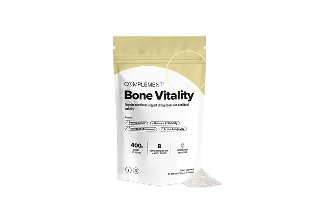 A white and beige pouch labeled Complement Bone Vitality stands upright, with some powder spilled beside it, promoting support for bone strength, movement, and longevity.
