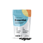 A colorful, resealable pouch labeled COMPLEMENT® Essential from Complement stands upright, with black capsules nearby. The package highlights plant-based multivitamin ingredients like B12, D3, K2, DHA/EPA omega-3s, iodine, zinc, magnesium, and selenium.