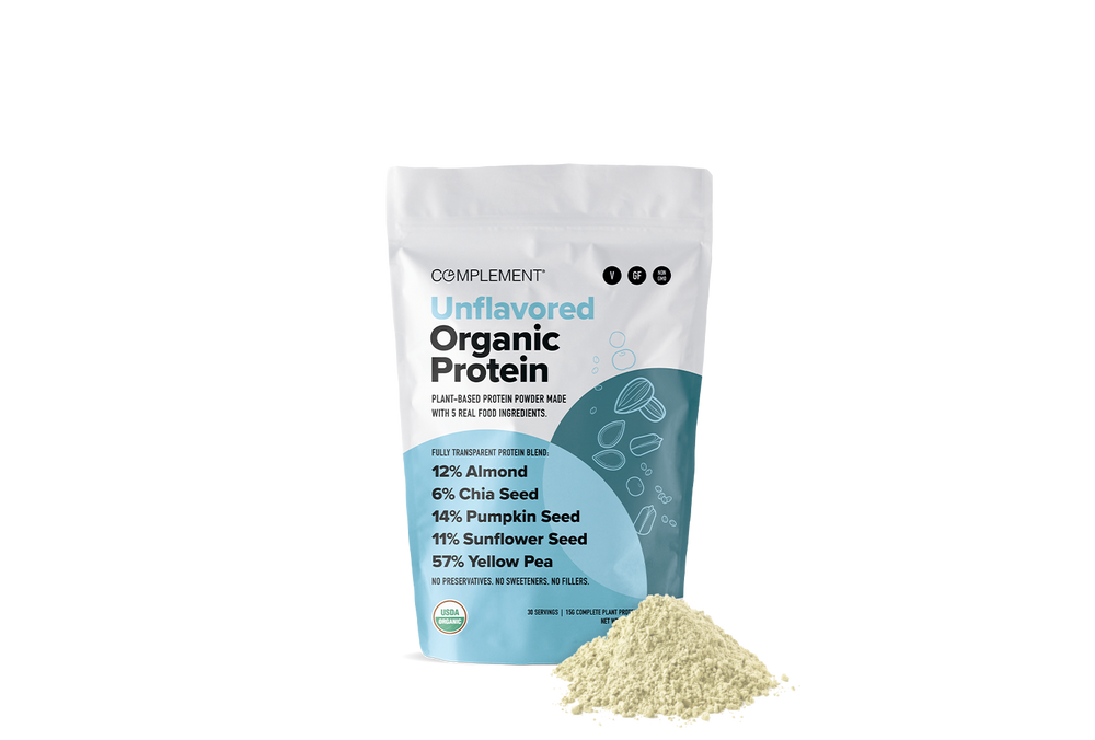 A white pouch labeled “Unflavored Organic Protein” with blue accents stands upright beside a small mound of beige protein powder. Ingredients and their percentages are listed on the pouch, including almond, chia, pumpkin, sunflower, and yellow pea.