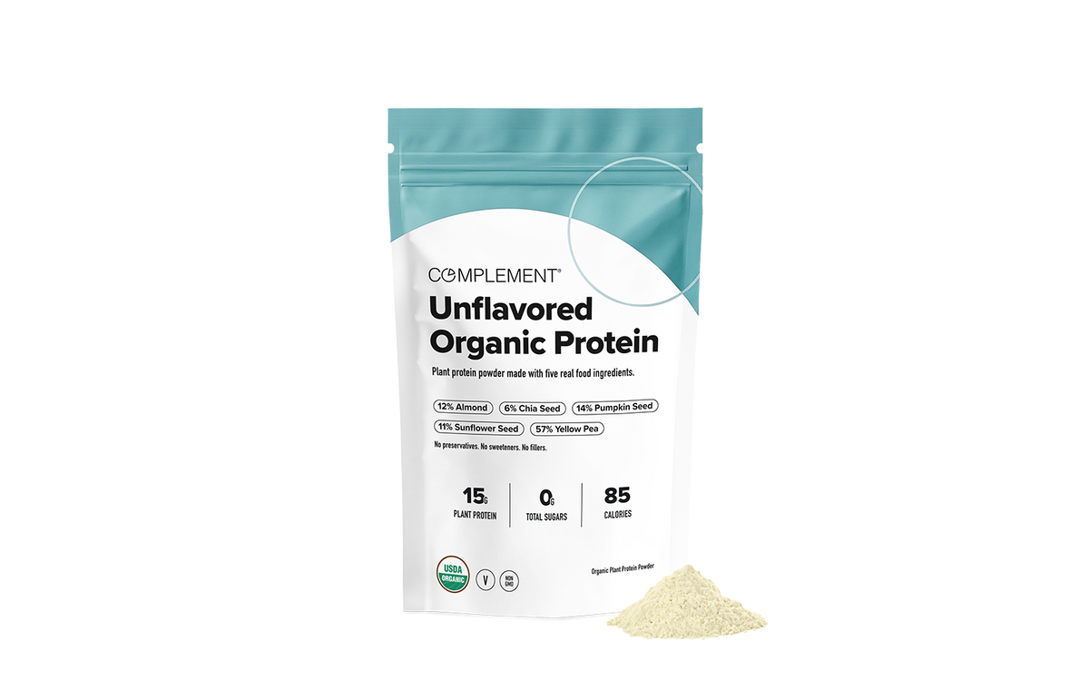 A bag of Complement Unflavored Organic Protein powder with a pile of powder in front.