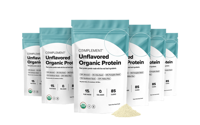 Six pouches of Complement Unflavored Organic Protein arranged in a semi-circle, with a small pile of powder in the foreground.