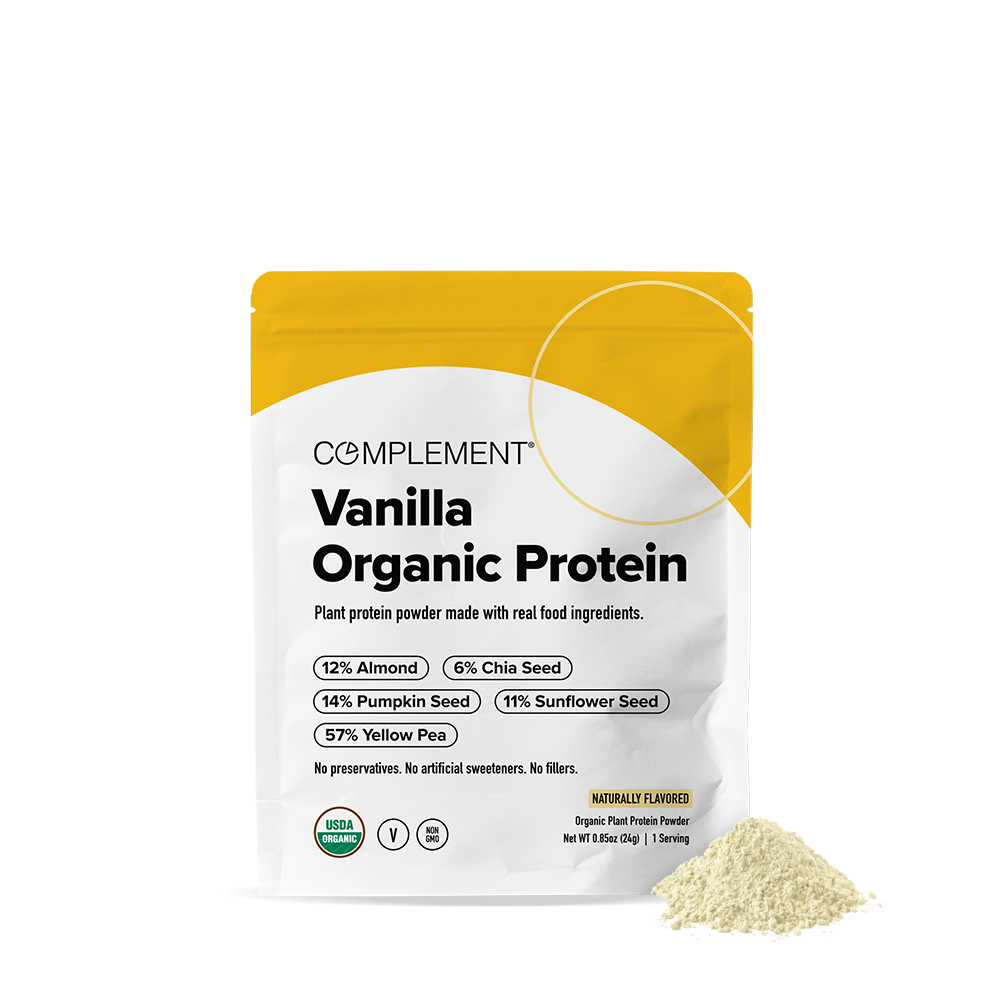 A white and yellow pouch labeled Complement Vanilla Organic Protein with nutritional details and a small pile of protein powder beside it on a white background.