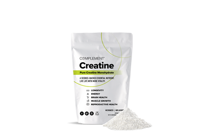 A white bag of Complement Creatine Monohydrate is displayed next to a small pile of white powder. The packaging highlights benefits such as longevity, energy, brain health, muscle growth, and reproductive health.