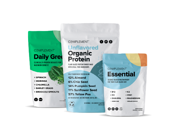 Three white pouches of Complement supplements. From left to right: Daily Greens featuring plant-based ingredients, Unflavored Organic Protein highlighting seed and pea protein, and Essential showcasing key nutrients like B12, DHA, and magnesium.