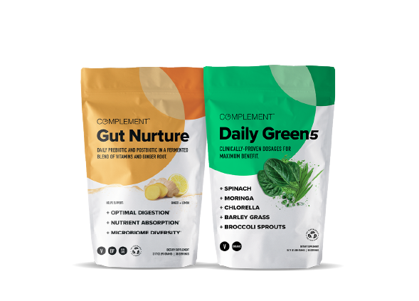 Two packages of Complement products are shown. The left package is labeled Gut Nurture with images of ginger and turmeric. The right package is labeled Daily Green5 and features images of spinach and other greens.