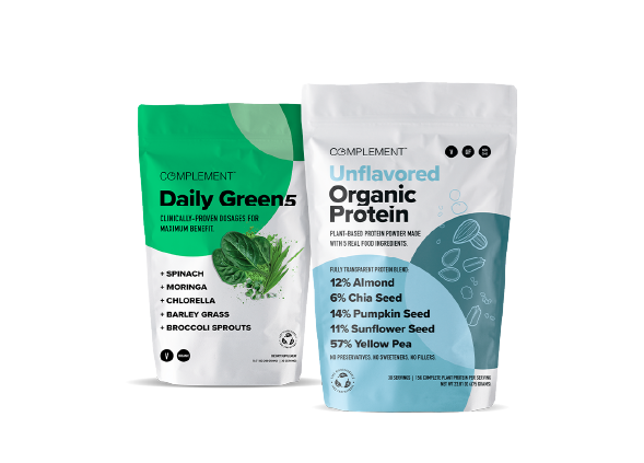 Two packets of Complement health supplements. One is Daily Green with ingredients like spinach and broccoli sprouts. The other is Unflavored Organic Protein including almond and chia seed. Both packets are standing side by side.