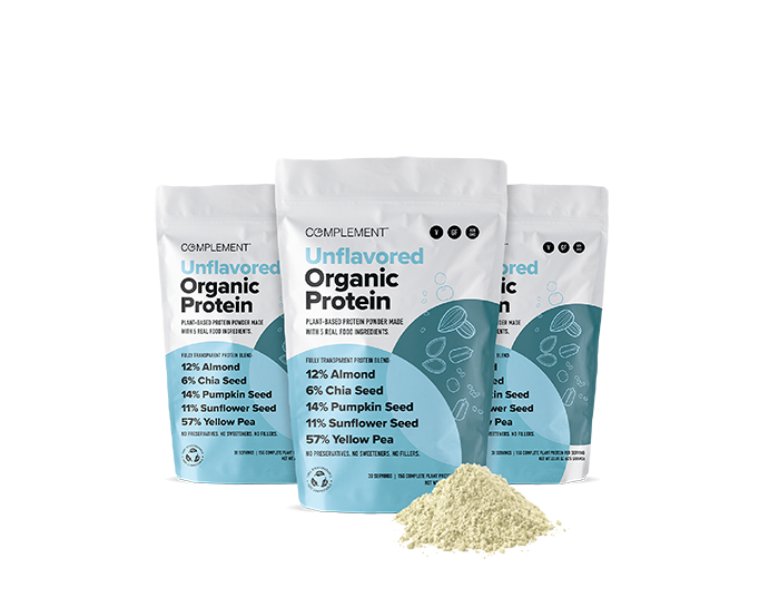 Three bags of Complement Organic Protein powder displayed side by side, labeled Unflavored Organic Protein with ingredients like almond, chia seed, pumpkin seed, sunflower seed, and yellow pea. A small pile of protein powder is in front.