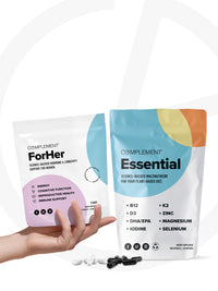 A hand holds a pill against a white background. To the left, a pouch labeled ForHer Essential System Multinutrient promises hormonal balance for womens health. On the right, another Complement pouch highlights essential nutrients like B12, K2, and Zinc. Capsules are scattered below.