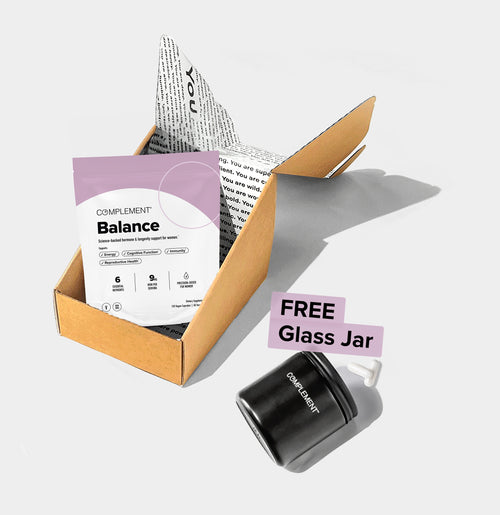 A brown box with a Balance supplement pouch inside, next to a black glass jar labeled Complement with a FREE Glass Jar tag on a white background.