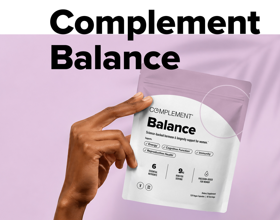 A hand holds a pouch labeled Complement Balance against a lavender background. Large text above matches the product name. The packaging lists benefits like energy, cognitive function, immunity, and reproductive health.