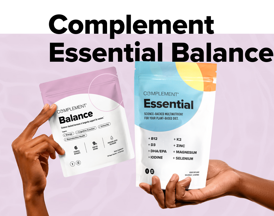Two hands hold Complement Balance and Complement Essential supplement pouches against a pastel background. Large black text above reads Complement Essential Balance..