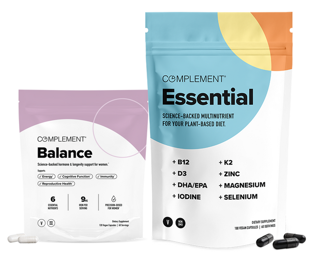 Two supplement packages: one labeled Balance in purple and white, and a larger one labeled Essential in blue and white, both from Complement, with capsules displayed in front of each package.