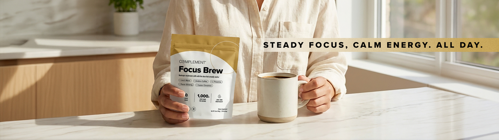 A person holds a bag of Complement Focus Brew coffee and a mug at a sunlit kitchen counter. Text reads: Steady focus, calm energy. All day.