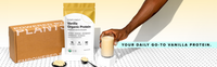 A hand holds a glass of vanilla protein shake next to a bag of Complement Vanilla Organic Protein, protein powder scoops, and a box labeled Powered by Plants. Text reads: Your daily go-to vanilla protein.