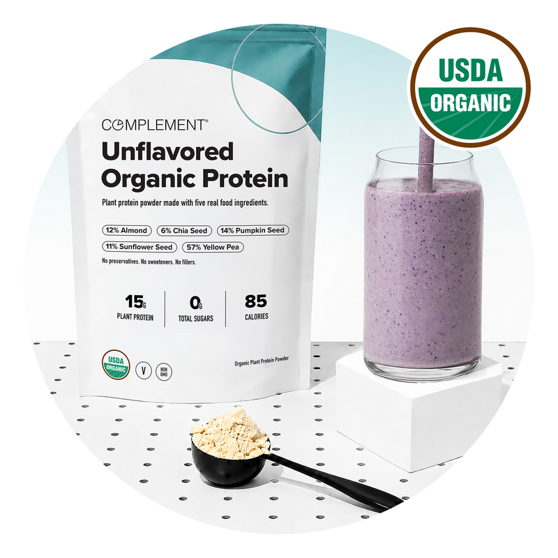 A bag of Complement Unflavored Organic Protein, a glass of purple smoothie with a straw, a scoop of powder, and a USDA Organic badge are displayed on a white surface with black dots.