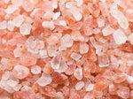 Close-up of coarse pink and white Himalayan salt crystals, showing their rough texture and irregular shapes.