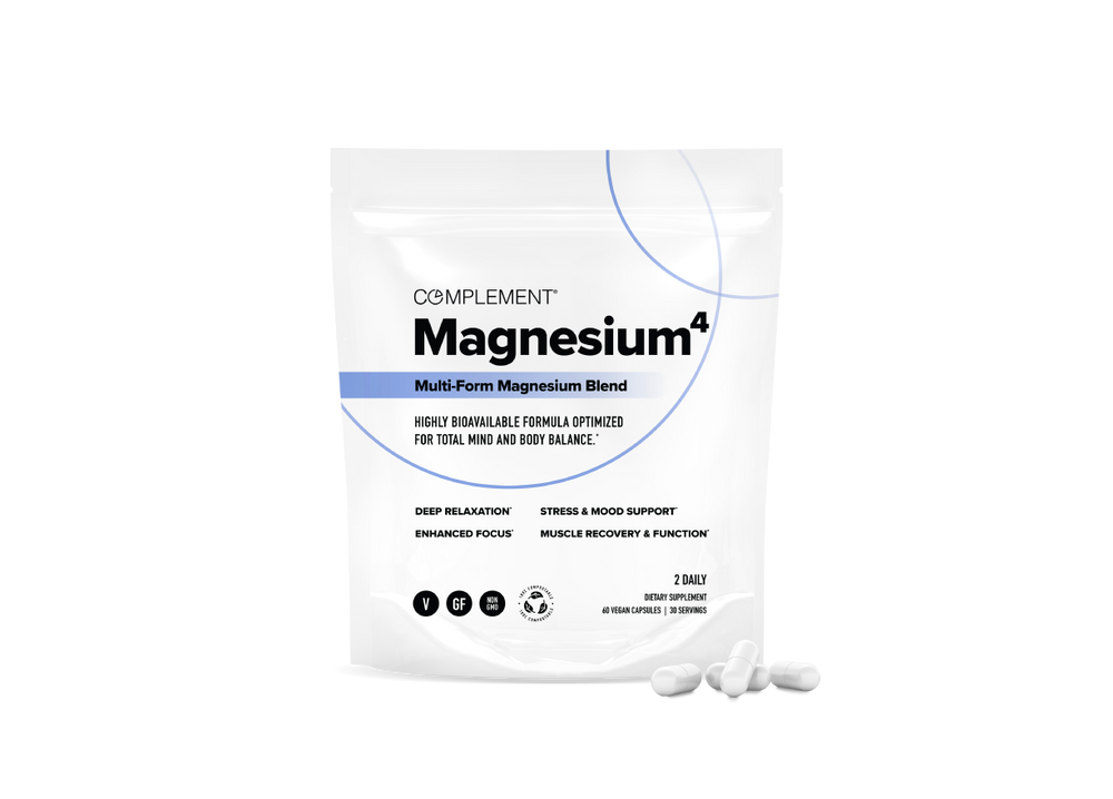 A white pouch labeled Complement Magnesium^4 Multi-Form Magnesium Blend stands upright with four white capsules in front. The packaging highlights benefits such as relaxation, focus, stress support, and muscle recovery.