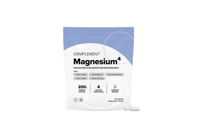A white and blue pouch labeled Complement Magnesium^4 dietary supplement is shown, featuring benefits like restful sleep and muscle relaxation; two white capsules are placed in front of the pouch.